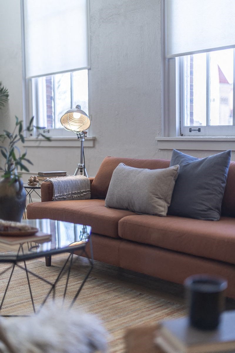 a living room with a brown couch and a table
