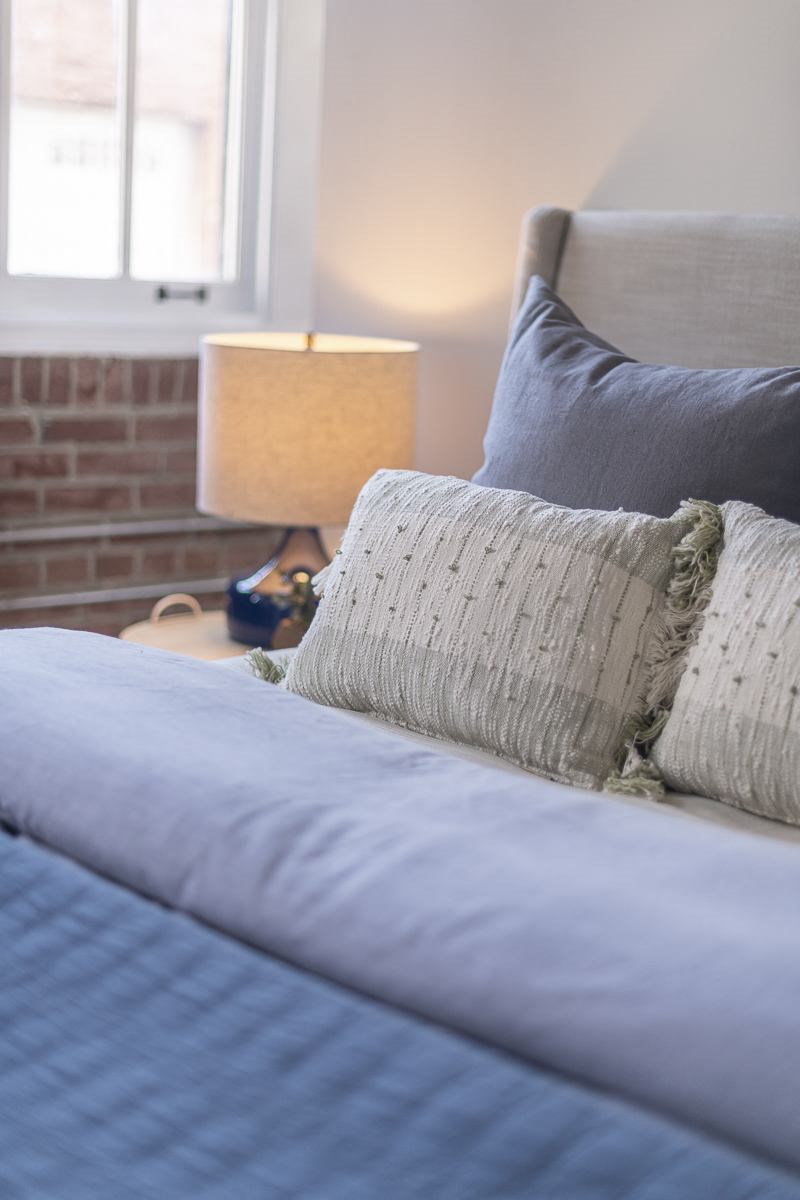 a bed with a blue comforter and pillows in a bedroom
