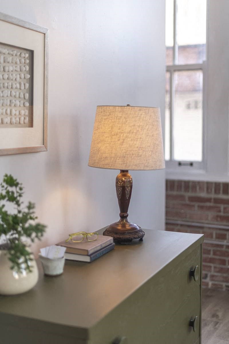 a table with a lamp and a book on it