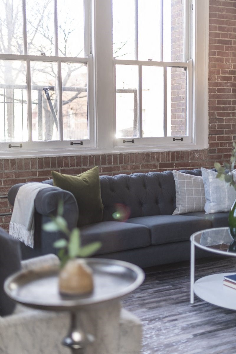 a living room with a couch and a brick wall