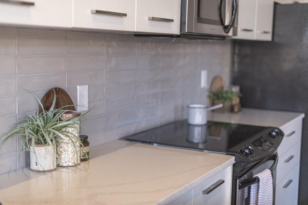 a small kitchen with white cabinets and a stove