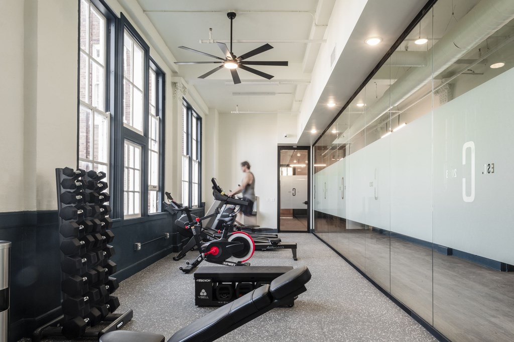 a man running on a treadmill in a gym with weights and other exercise equipment