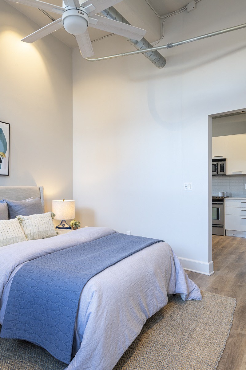 a bedroom with a bed and a ceiling fan