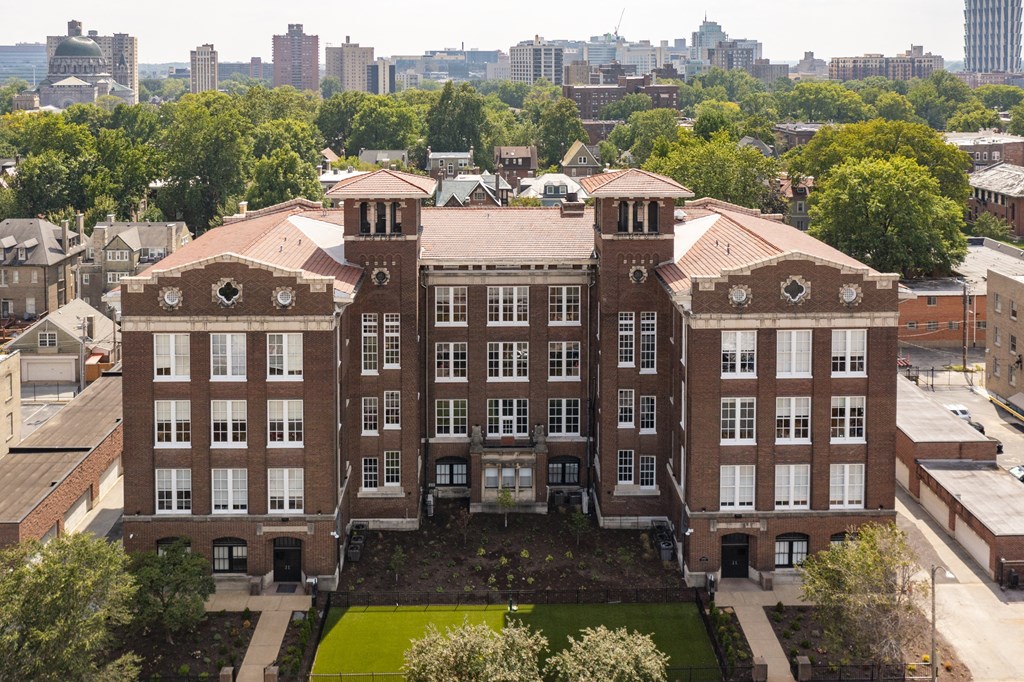 a large brick building with a city in the background