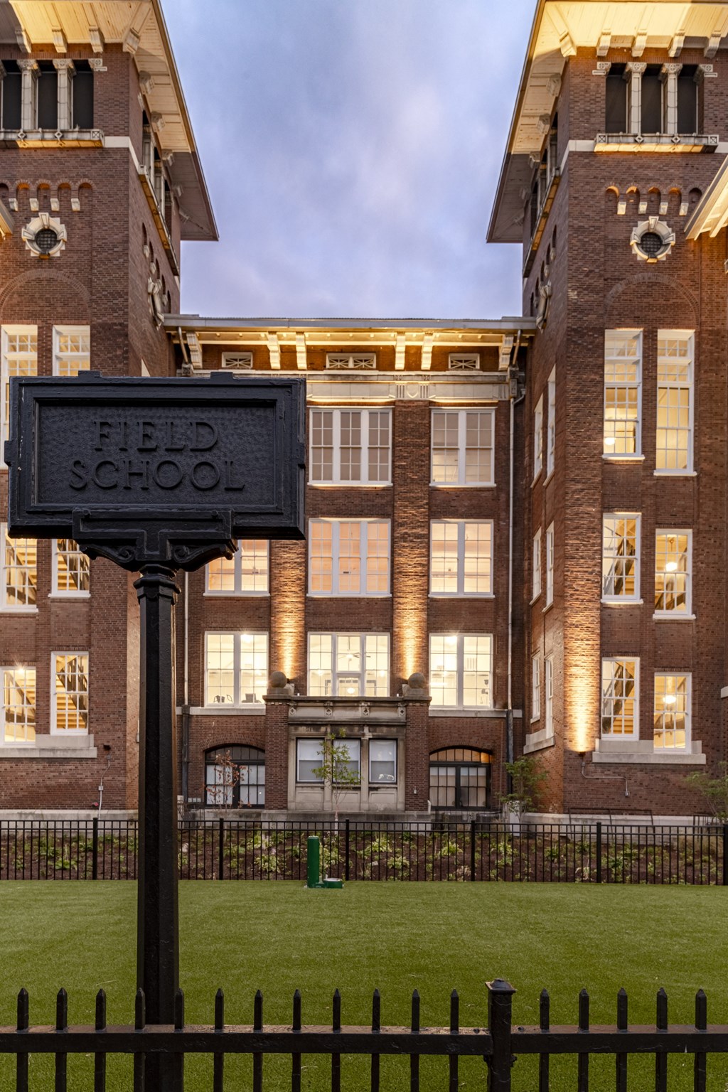 a large brick building with a sign in front of it