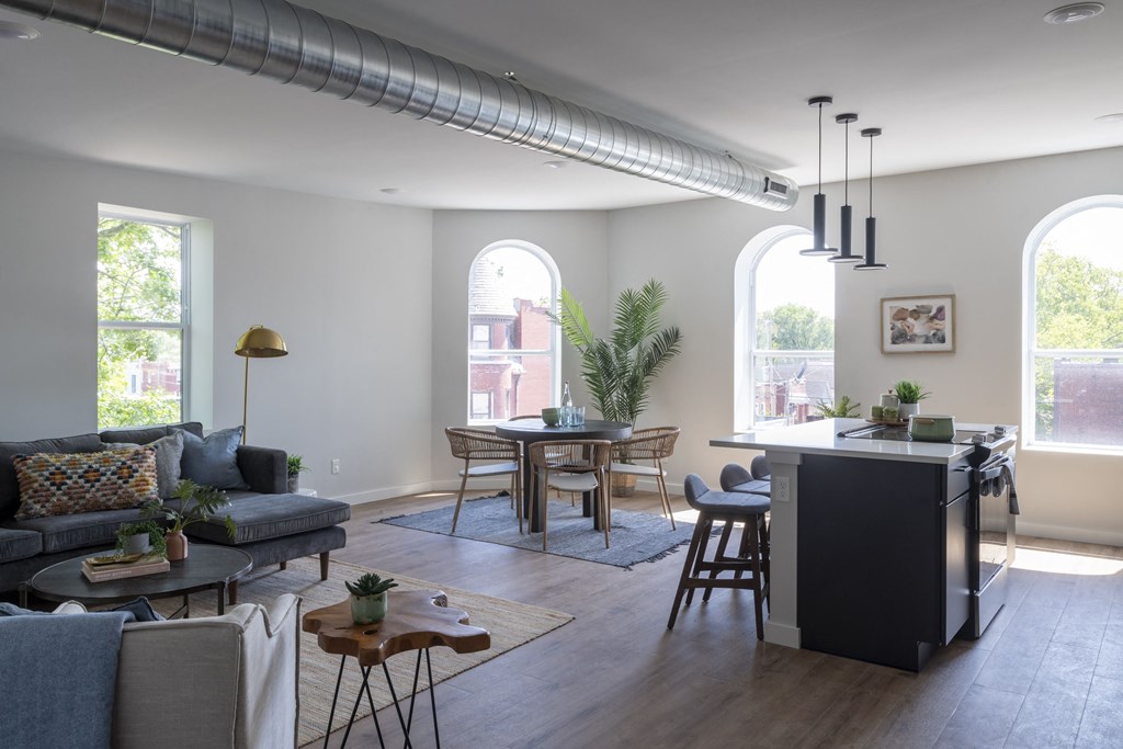 a living room with a kitchen and an island in the middle