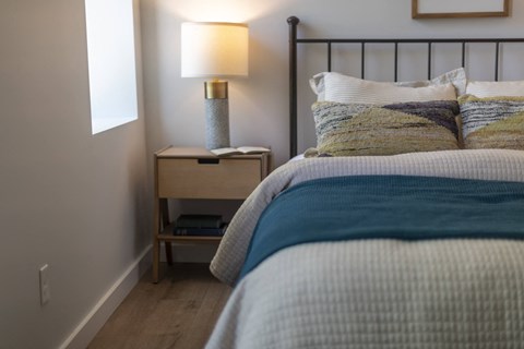 a bedroom with a bed and a nightstand with a lamp