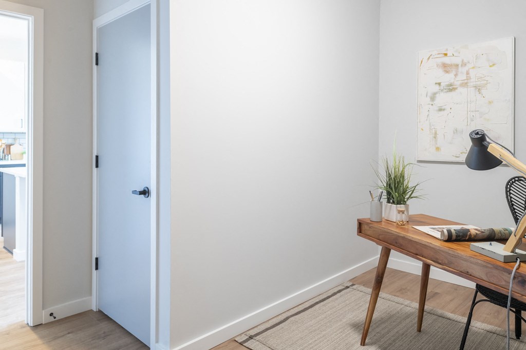 a home office with a wooden desk and a blue door