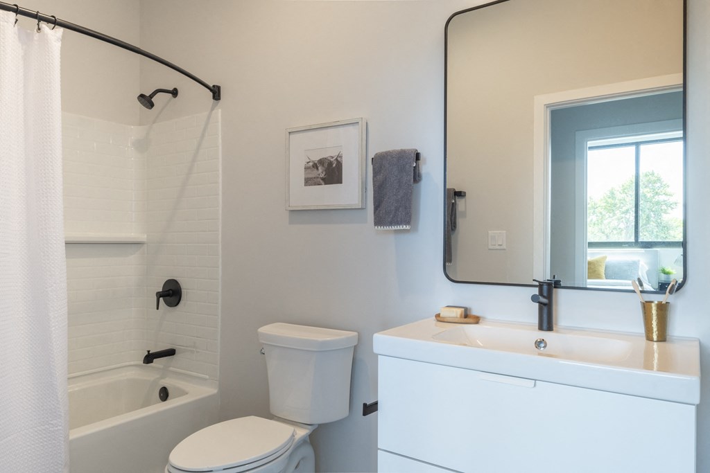 a bathroom with a toilet and a sink and a shower
