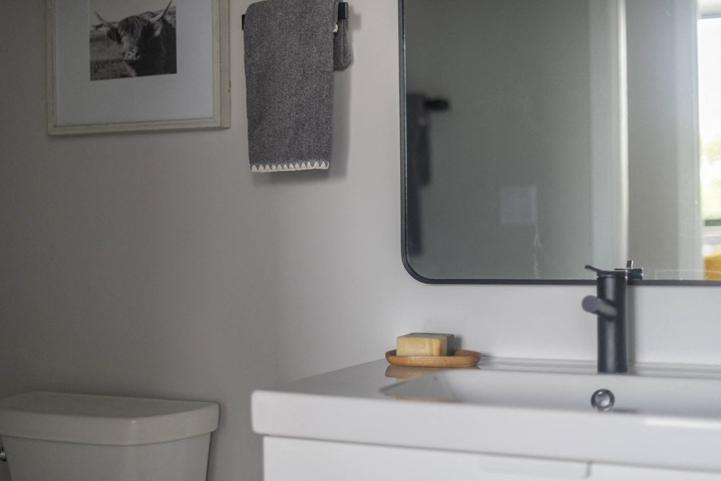 a small bathroom with a toilet and a sink and a mirror