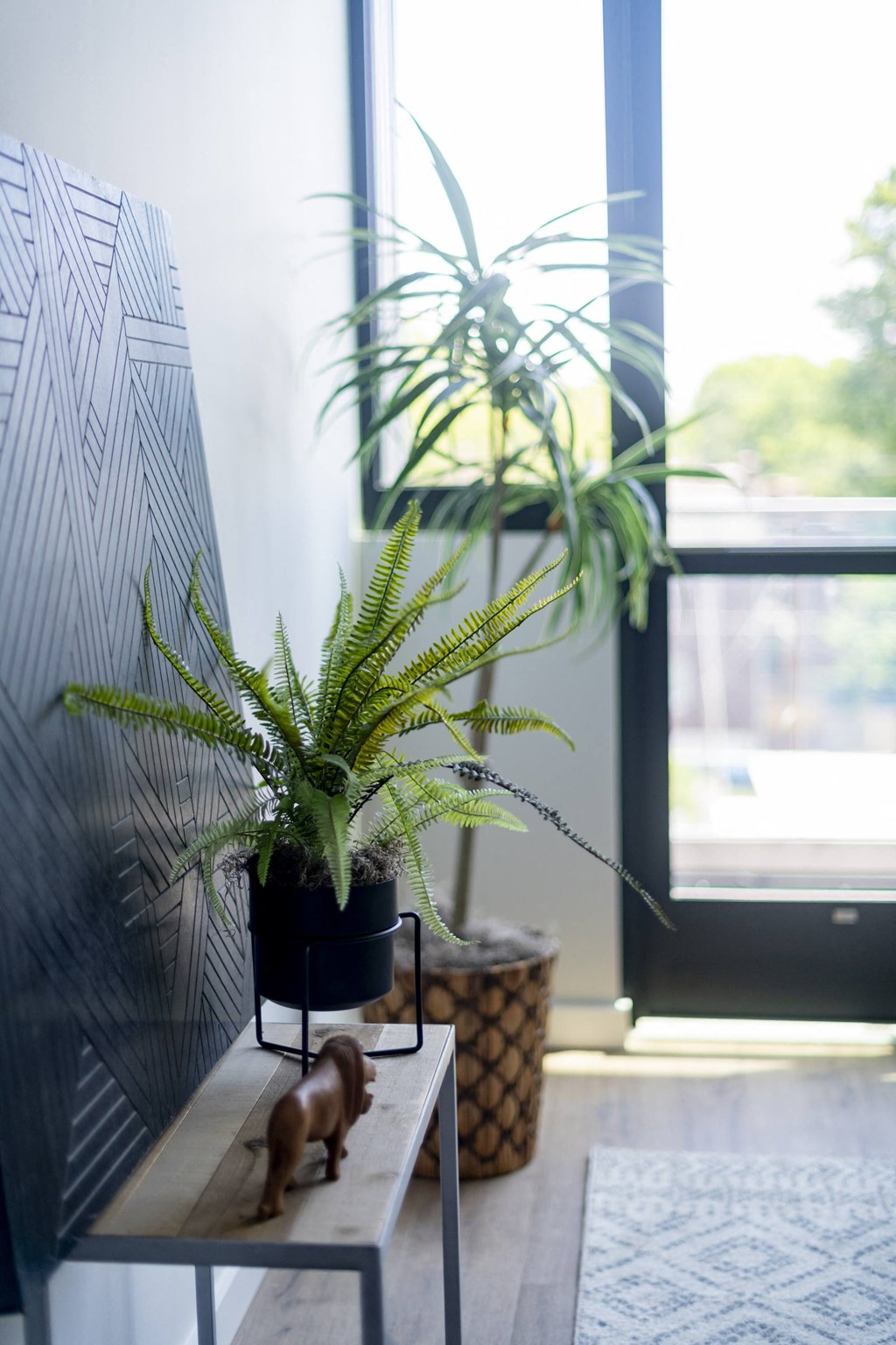 a small dog on a bench next to a potted plant