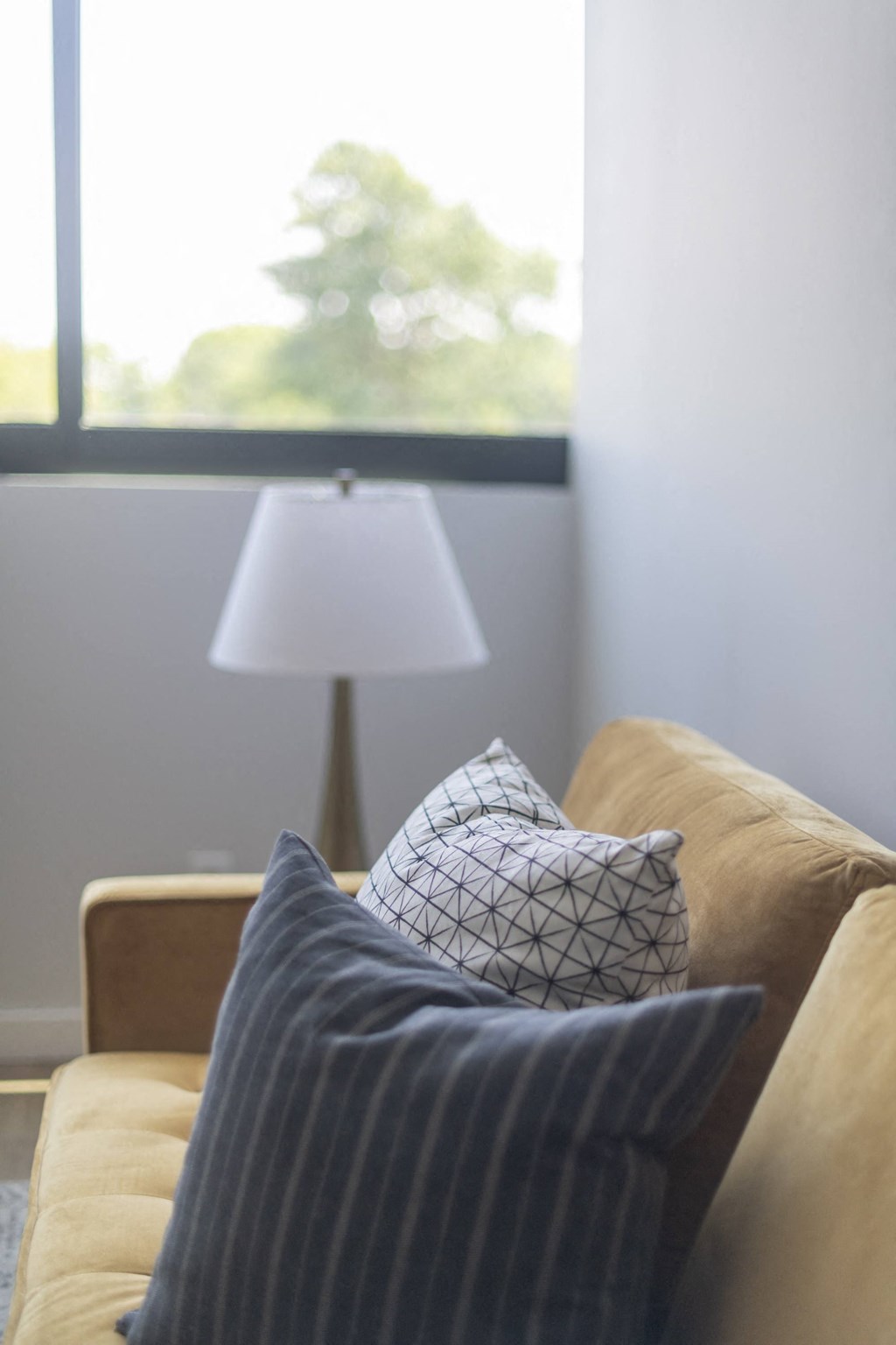 a couch with a pillow and a lamp in a living room