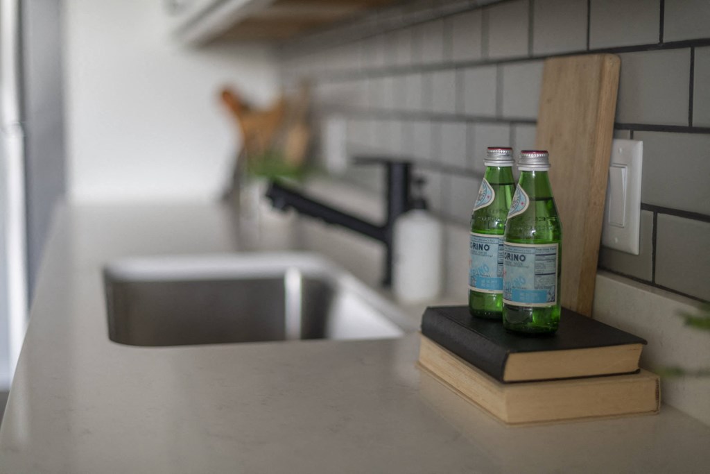 two bottles of spring water sit on a kitchen counter