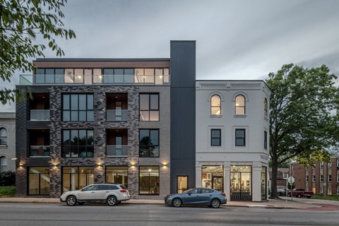 the exterior of a building with cars parked in front of it