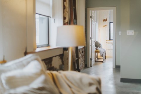 A cozy bedroom with a bed and a lamp.