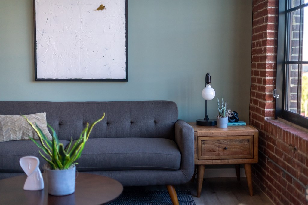 a living room with a gray couch and a wooden side table at The 22 Apartments, Missouri
