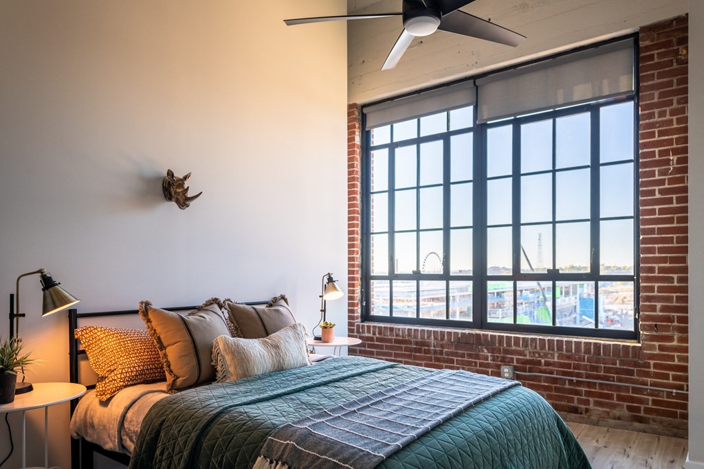 a bedroom with a large bed and a large window at The 22 Apartments, St. Louis, MO 63103