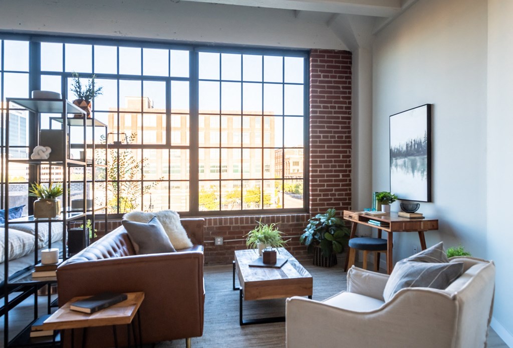 a living room filled with furniture and a large window at The 22 Apartments, St. Louis, 63103