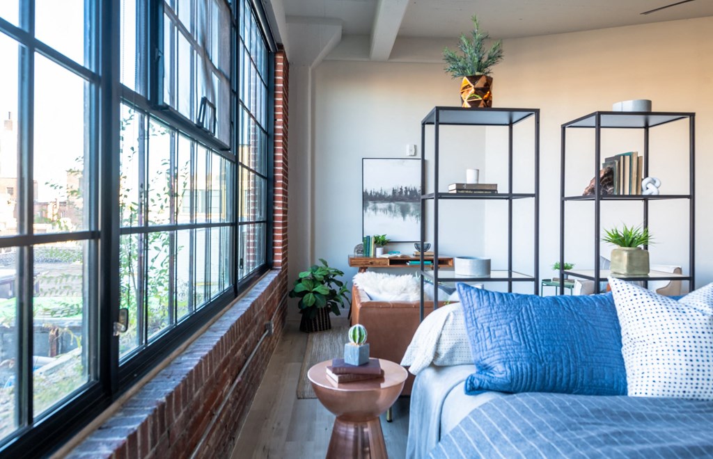 a bedroom with a bed and a large window at The 22 Apartments, St. Louis, MO