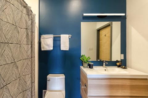 A bathroom with a blue wall and a wooden vanity.
