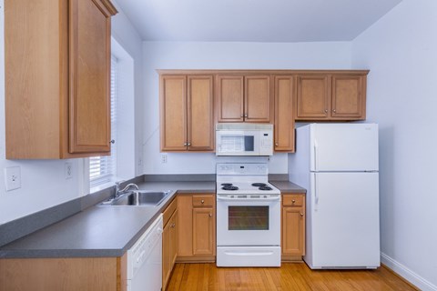 A kitchen with wooden cabinets and white appliances.
