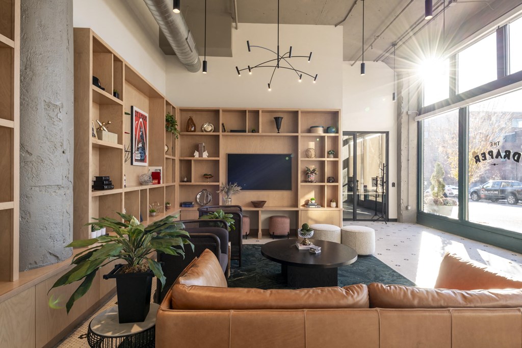 a living room with leather furniture and a large window at The Draper, Missouri, 63103