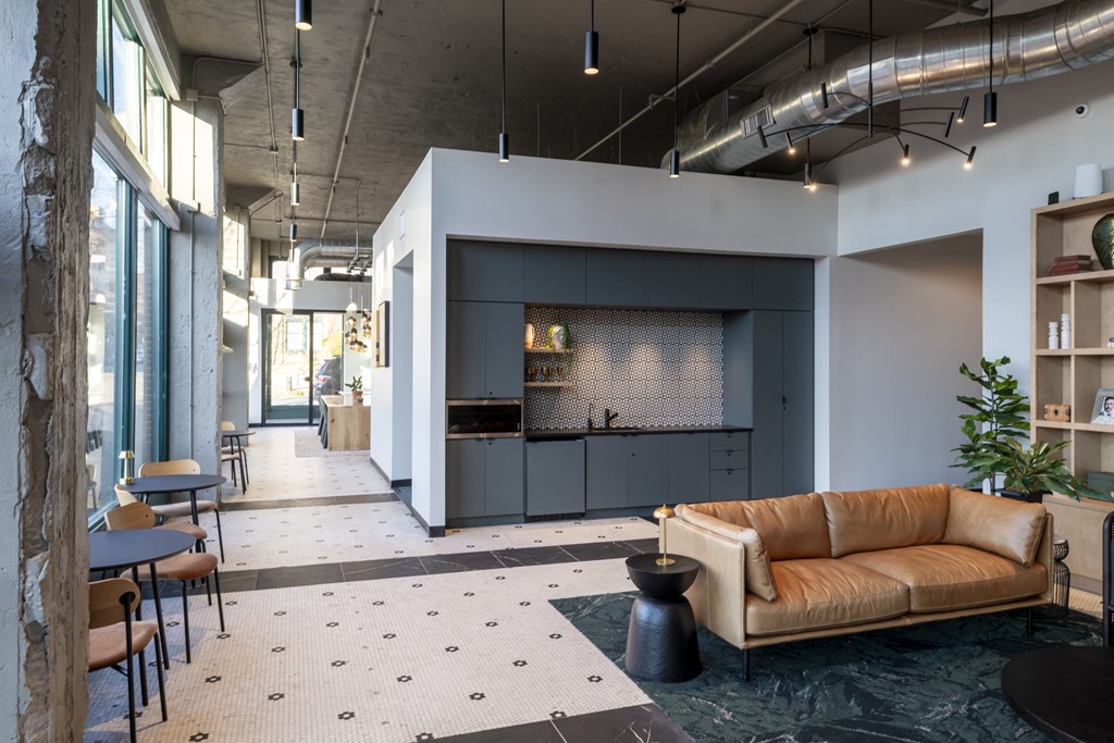 a living room with a couch and a kitchen at The Draper, St Louis, MO, 63103