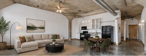 A living room with a couch, a table, and a painting on the wall.