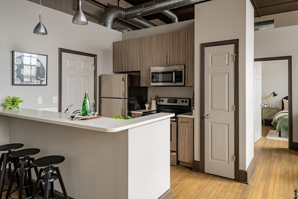 an open kitchen and living room with a bar and stools
