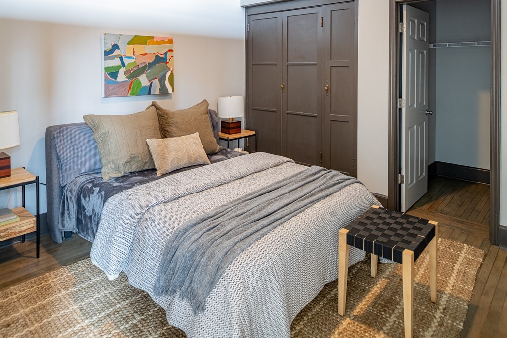 a bedroom with a bed and a blue and white comforter