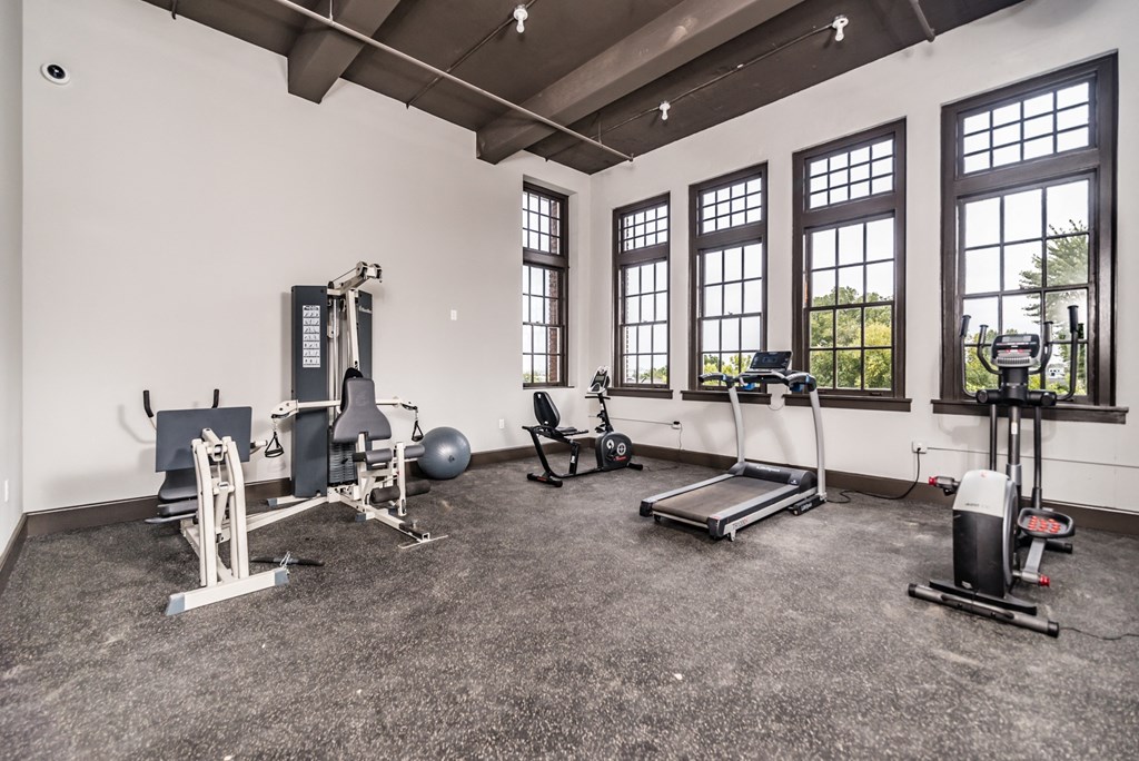gym with exercise equipment and windows at the district flats apartments in lenexa