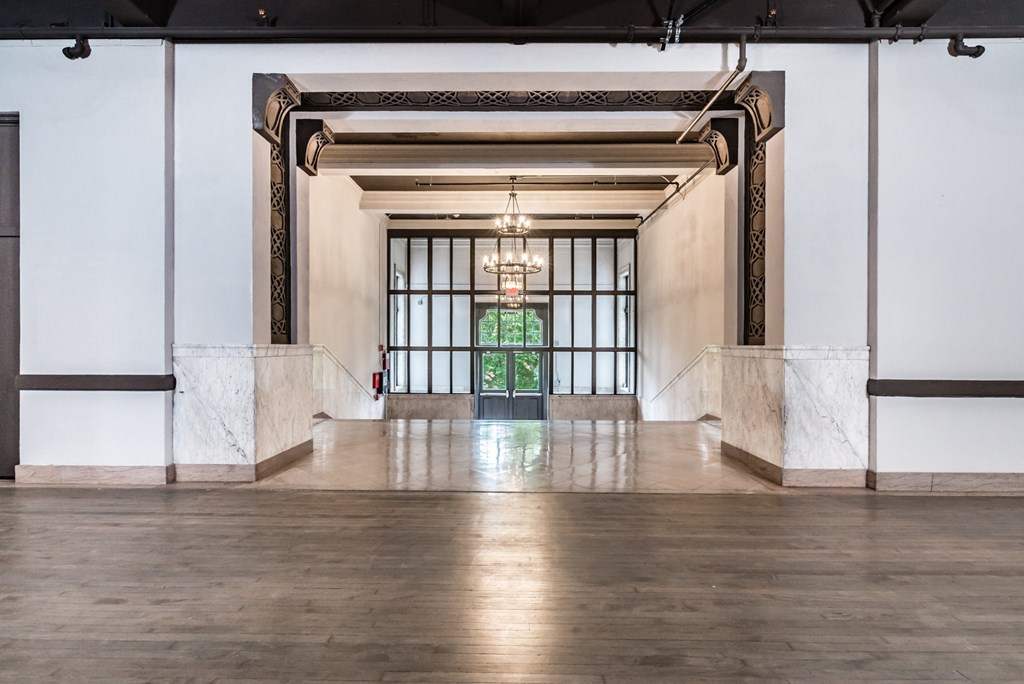 a large empty room with a large window and a chandelier