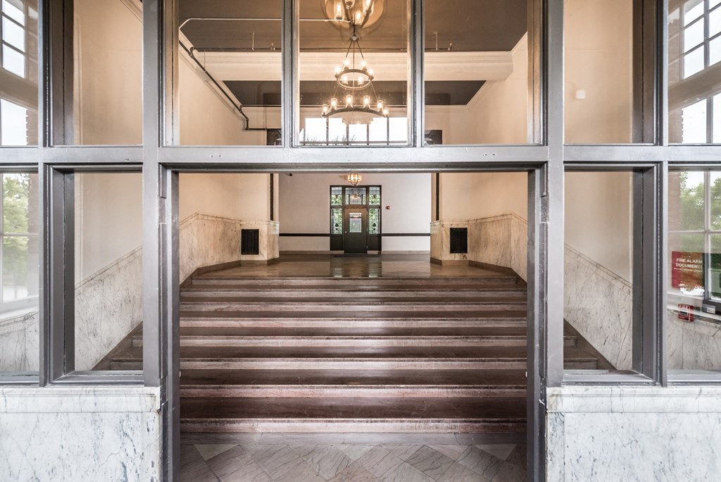 the lobby of a building with large windows and a large set of stairs