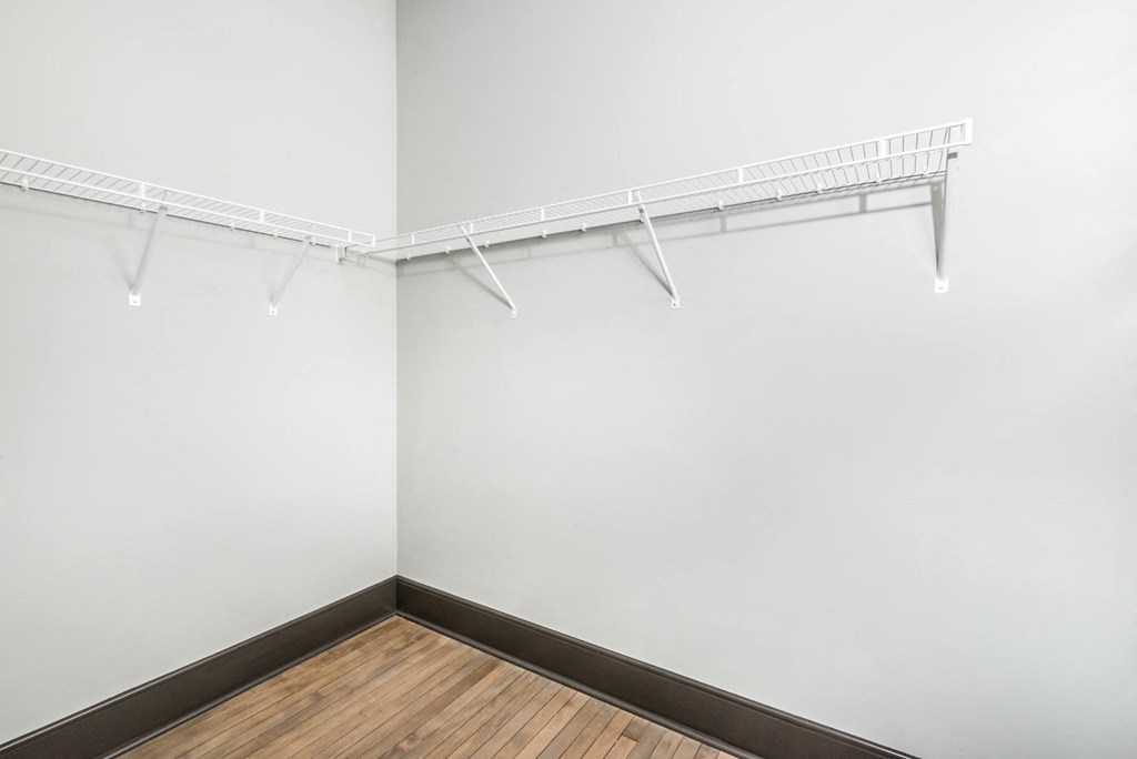 an empty room with a white wall and a hanging rack