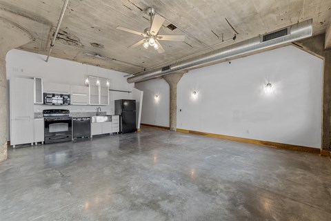 A spacious garage with a concrete floor and a ceiling fan.