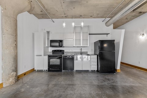 A kitchen with black appliances and white cabinetry.