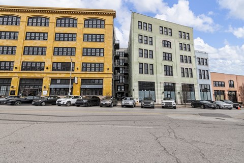A parking lot with cars and two buildings.