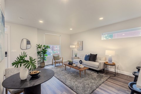 A living room with a black table and a white couch.