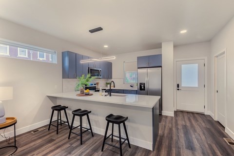 A kitchen with a bar stool and a counter.