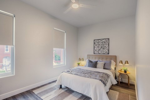 A bedroom with a large bed and a ceiling fan.