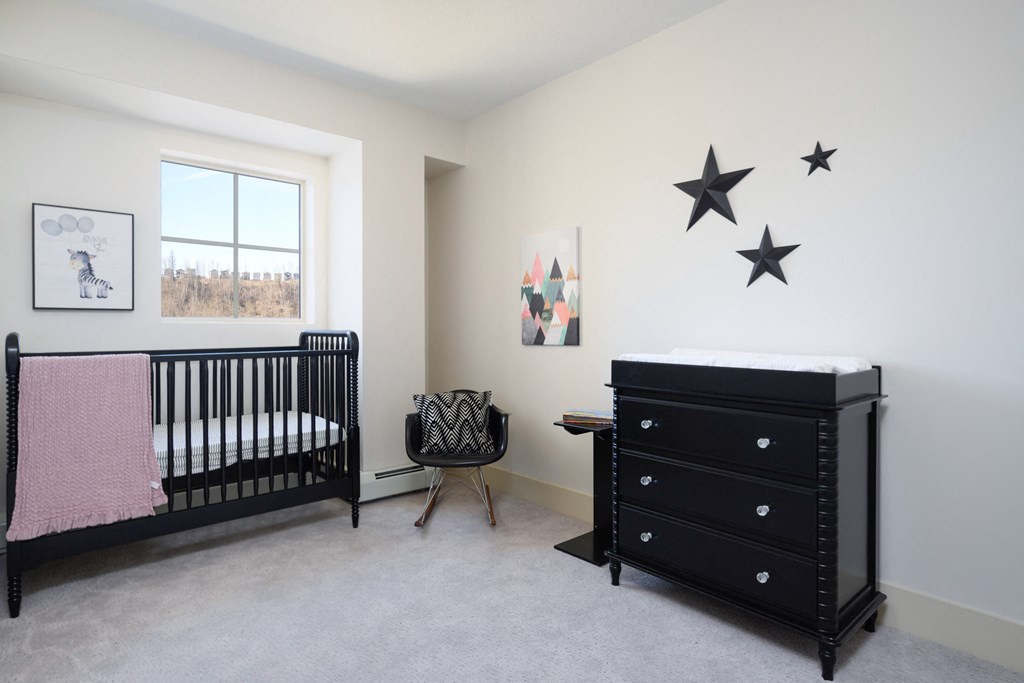 a nursery with a crib and dresser and stars on the wall