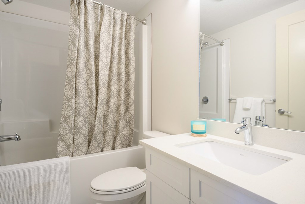 a white bathroom with a shower and a sink and a toilet