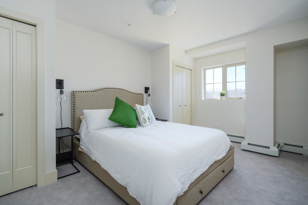 a bedroom with a white bed and a green pillow