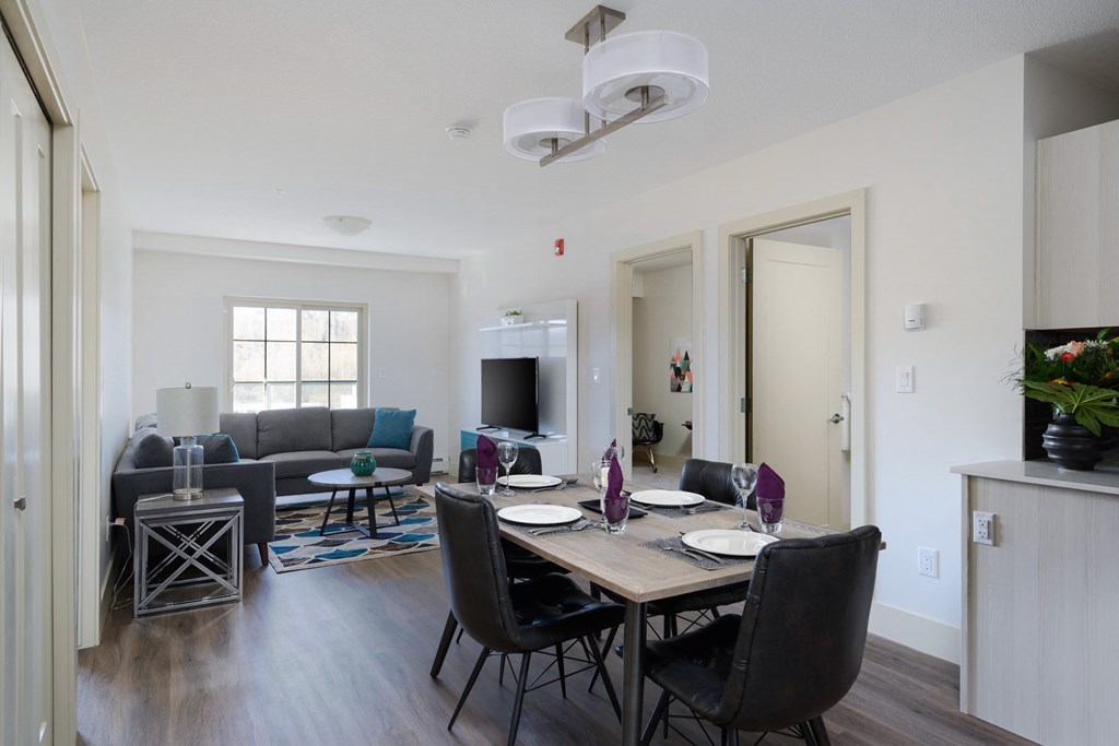 a living room and dining room with a table and chairs