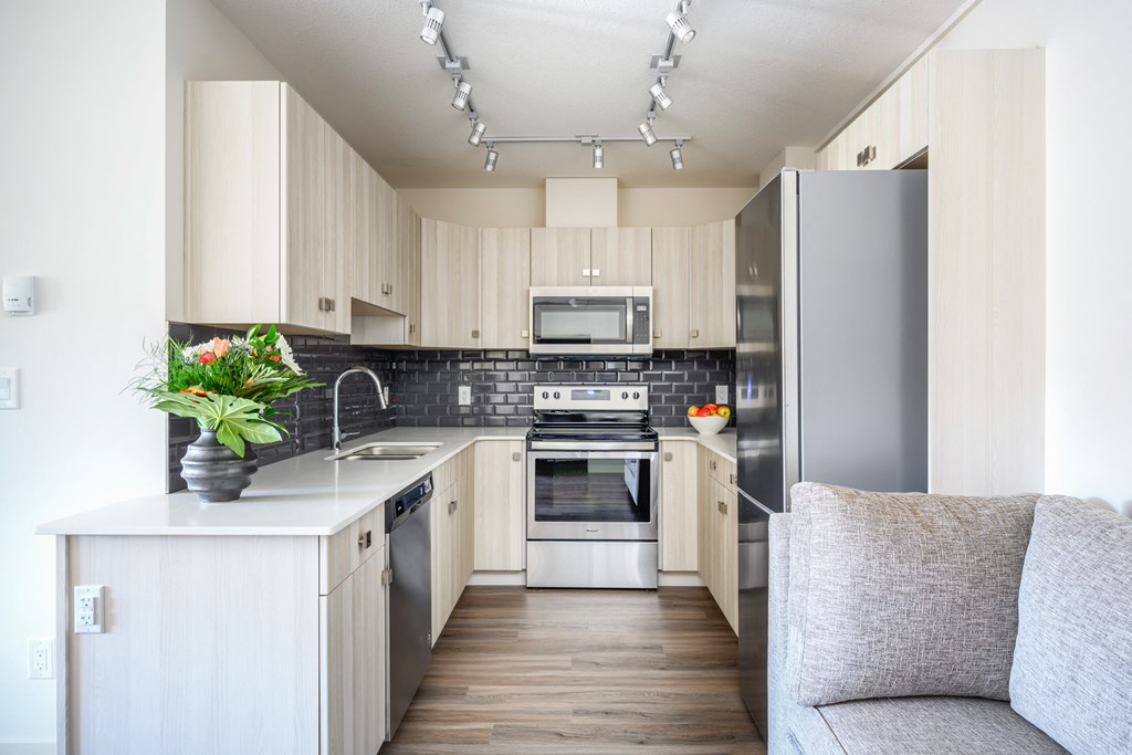 a modern kitchen with white cabinets and stainless steel appliances
