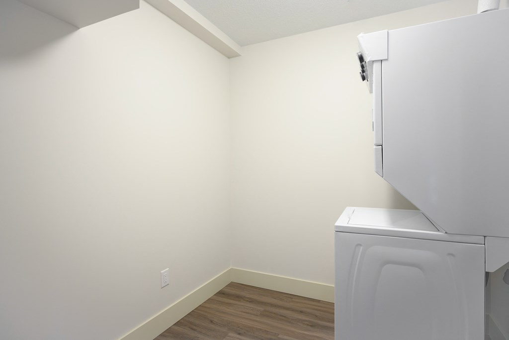 an empty room with a refrigerator and a washing machine