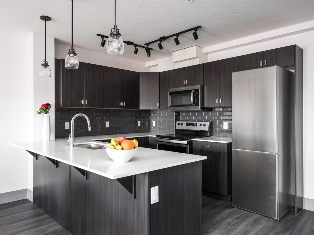 a kitchen with stainless steel appliances and a marble counter top