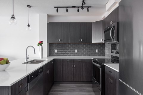 a kitchen with dark wood cabinets and a white counter top