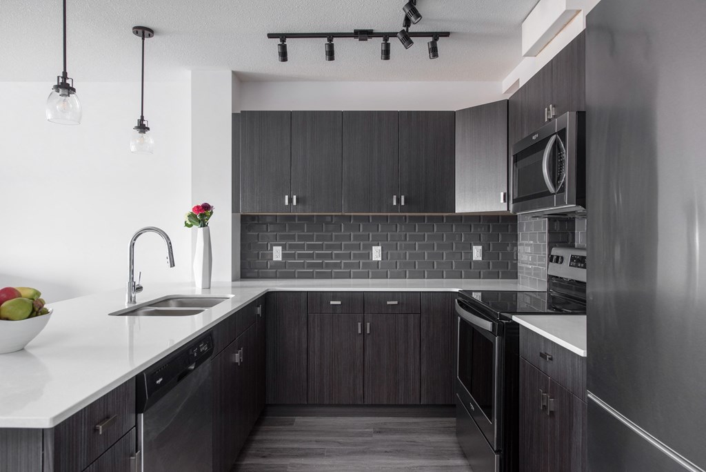 a kitchen with dark wood cabinets and a white counter top
