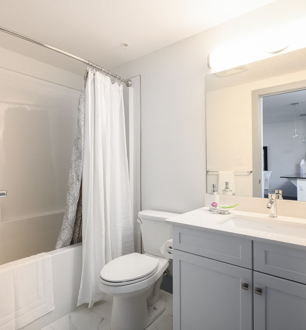 a white bathroom with a sink toilet and shower